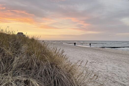 Faszinierende Küstenlandschaft mit ruhigem Wasser, goldenem Sand und atemberaubendem Sonnenuntergang