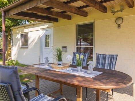 überdachte Terrasse mit Gartenmöbeln