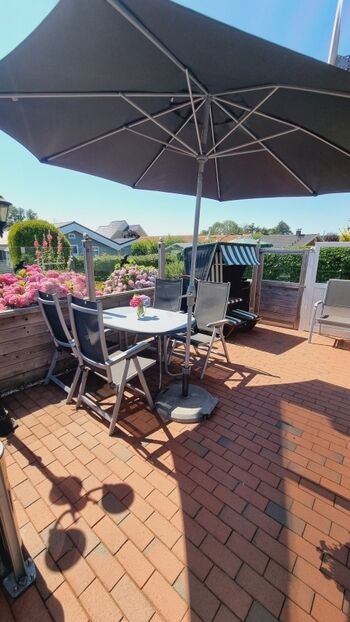 Die große Terrasse mit Sonnenschirm und Windschutz