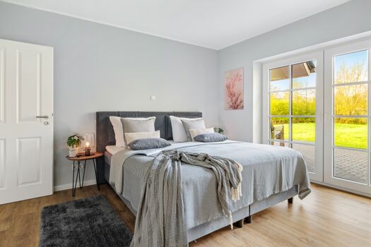 Schlafzimmer mit TV und Zugang zur Terrasse