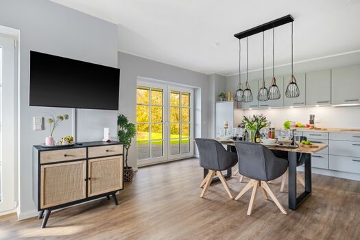 Blick in den Essbereich mit offener Küche und Zugang zur Terrasse