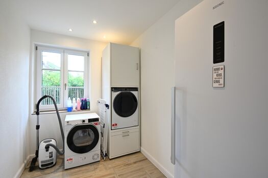 Wirtschaftsraum mit großem Gefrierschrank, Waschmaschin, Trockner, Staubsauger etc.