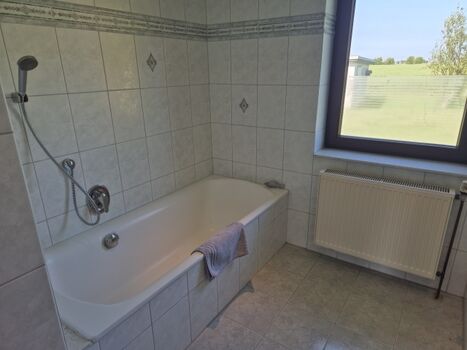 Badezimmer mit Badewanne und Dusche