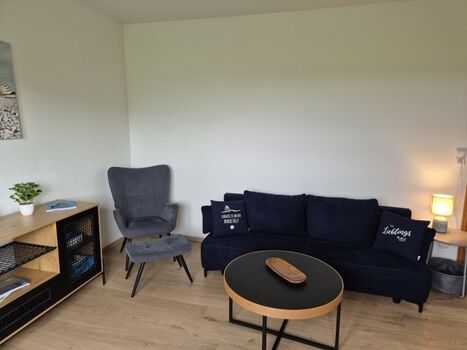 Gemütliches Wohnzimmer mit Schlafsessel und Schlafsofa