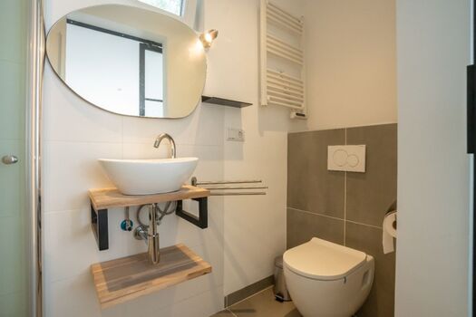 Das neue Badezimmer mit Regendusche, Waschbecken und WC