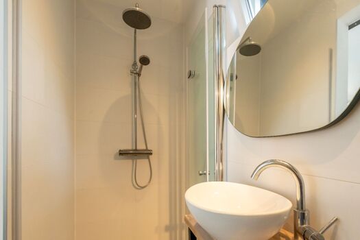 Das neue Badezimmer mit Regendusche, Waschbecken und WC