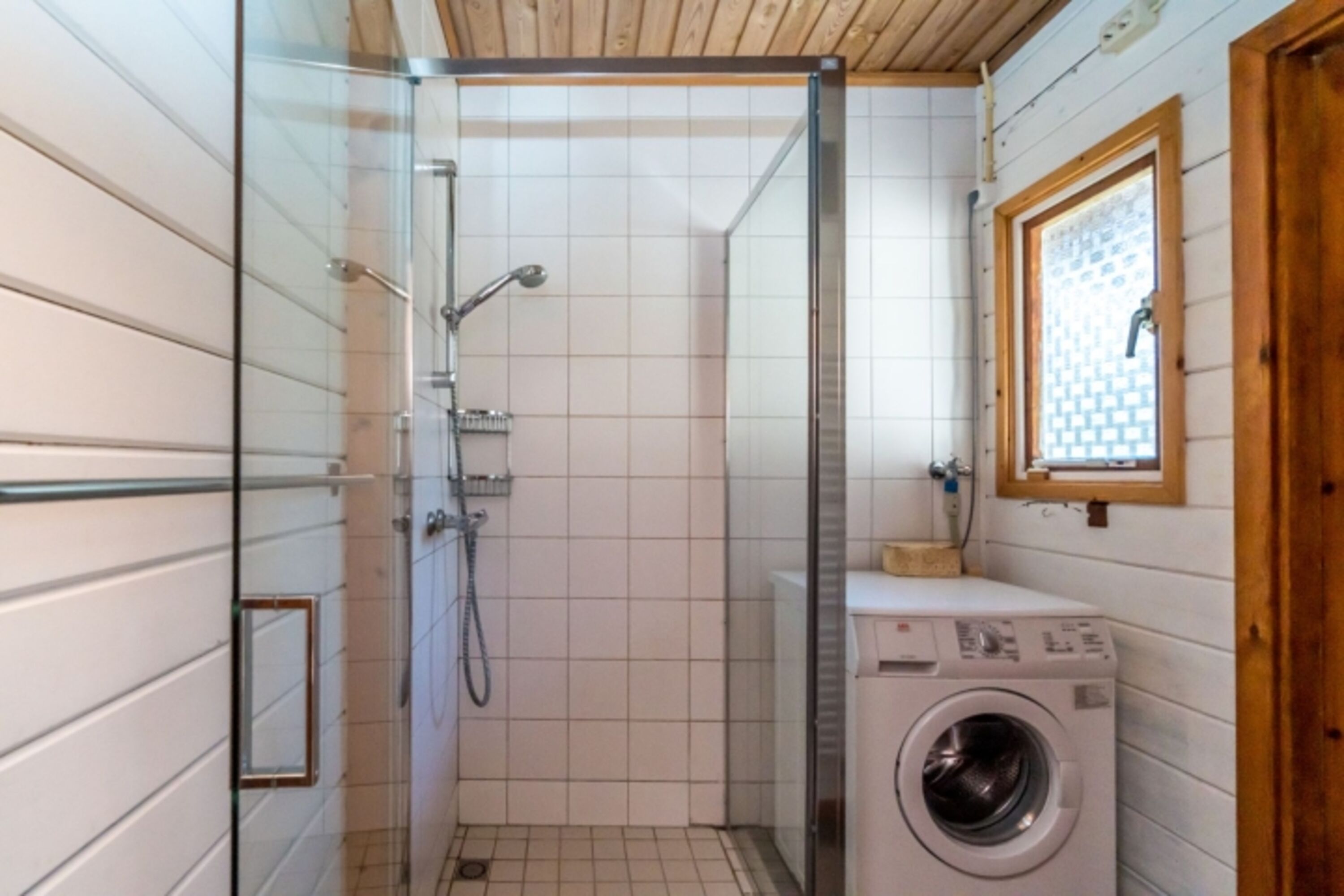 Badezimmer mit Dusche und Waschmaschine