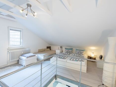 Schlafempore mit Doppelbett und Einzelbett