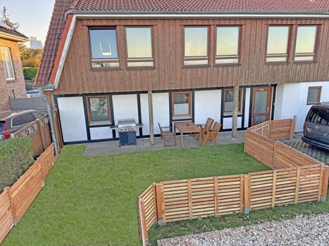 vollständig eingezäunte Terrasse mit Garten und Gasgrill