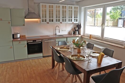 Küche mit großem Esstisch und Schlafcouch