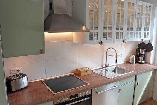 Küche mit großem Esstisch und Schlafcouch