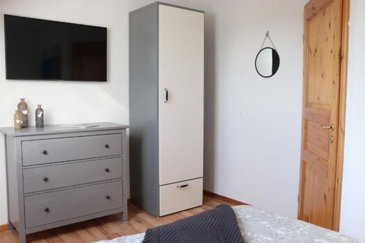 Schlafzimmer mit Doppelbett und Smart-TV