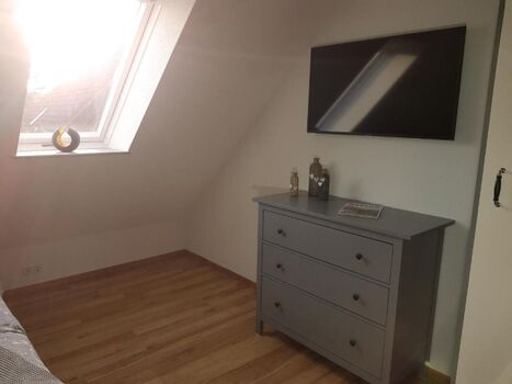 Schlafzimmer mit Doppelbett und Smart-TV