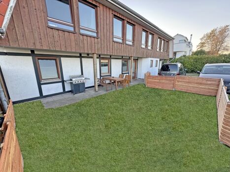 vollständig eingezäunte Terrasse mit Garten und Gasgrill