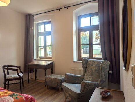 Neben dem gemütlichen Sessel bietet der Schlafraum einen kleinen Schreib-/Kosmetiktisch