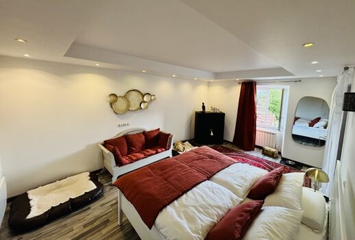 An das große, rote Schlafzimmer schließt sich hinten rechts der begehbare Kleiderschrank mit Tageslicht an