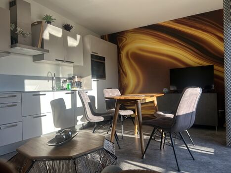 Wohnzimmer mit sehr gut eingerichteter Küchnziel