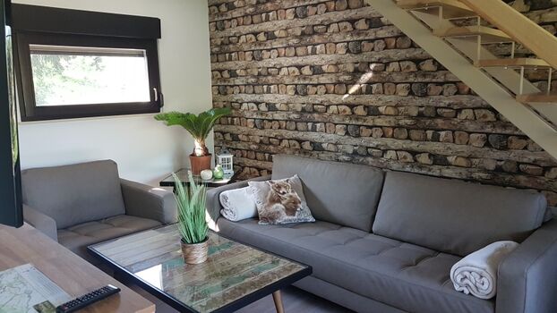 gemütliche Couch und Sessel im Wohnzimmer 