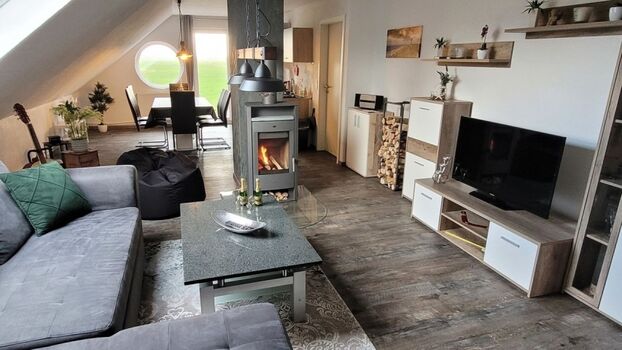 Blick vom Wohnbereich über den Kamin in die Küche und Terrasse