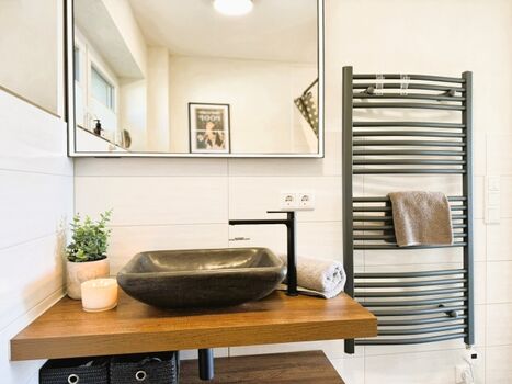 Bad mit Dusche, Waschtisch, Handtuch und Fußbodenheizung