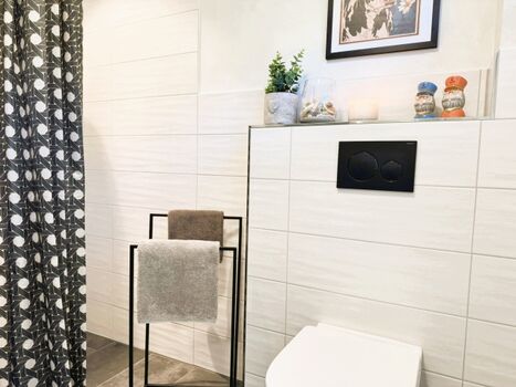 Bad mit Dusche, Waschtisch, Handtuch und Fußbodenheizung