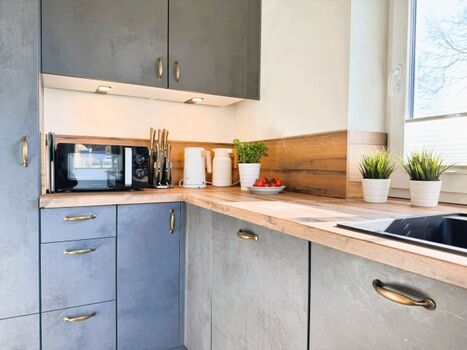 Moderne Küche mit Geschirrspüler, Mikrowelle, Herd, Ofen etc.