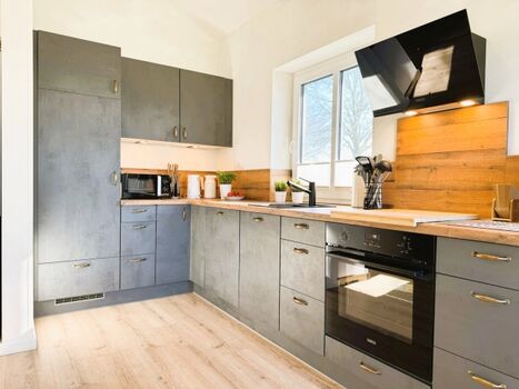 Moderne Küche mit Geschirrspüler, Mikrowelle, Herd, Ofen etc.