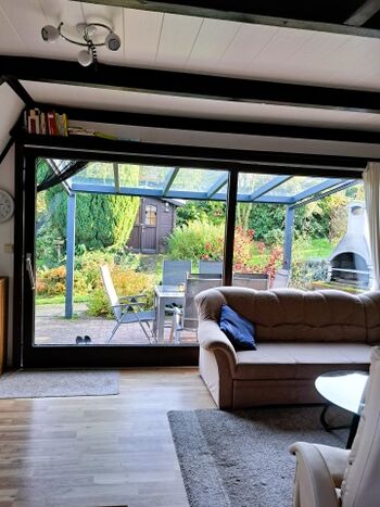 Blick aus Wohnzimmer auf Terrasse und Garten