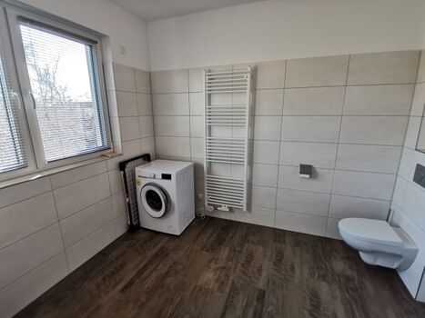 Im Badezimmer ist eine Waschmaschine