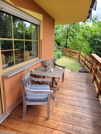 Überdachte Terrasse mit kleinem Gartenstück