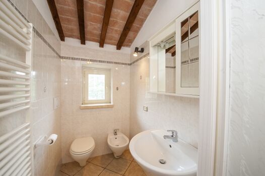 Auch in dem Badezimmer ist die Decke mit Holbalken bedeckt...