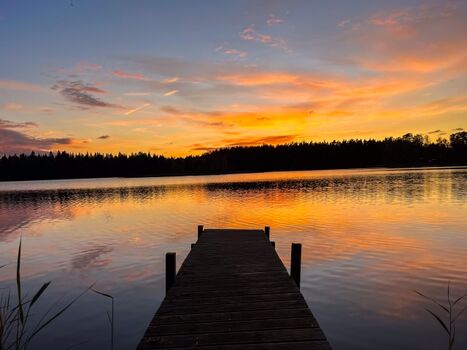 Der Steg im Sonnenuntergang über dem See in Schweden 