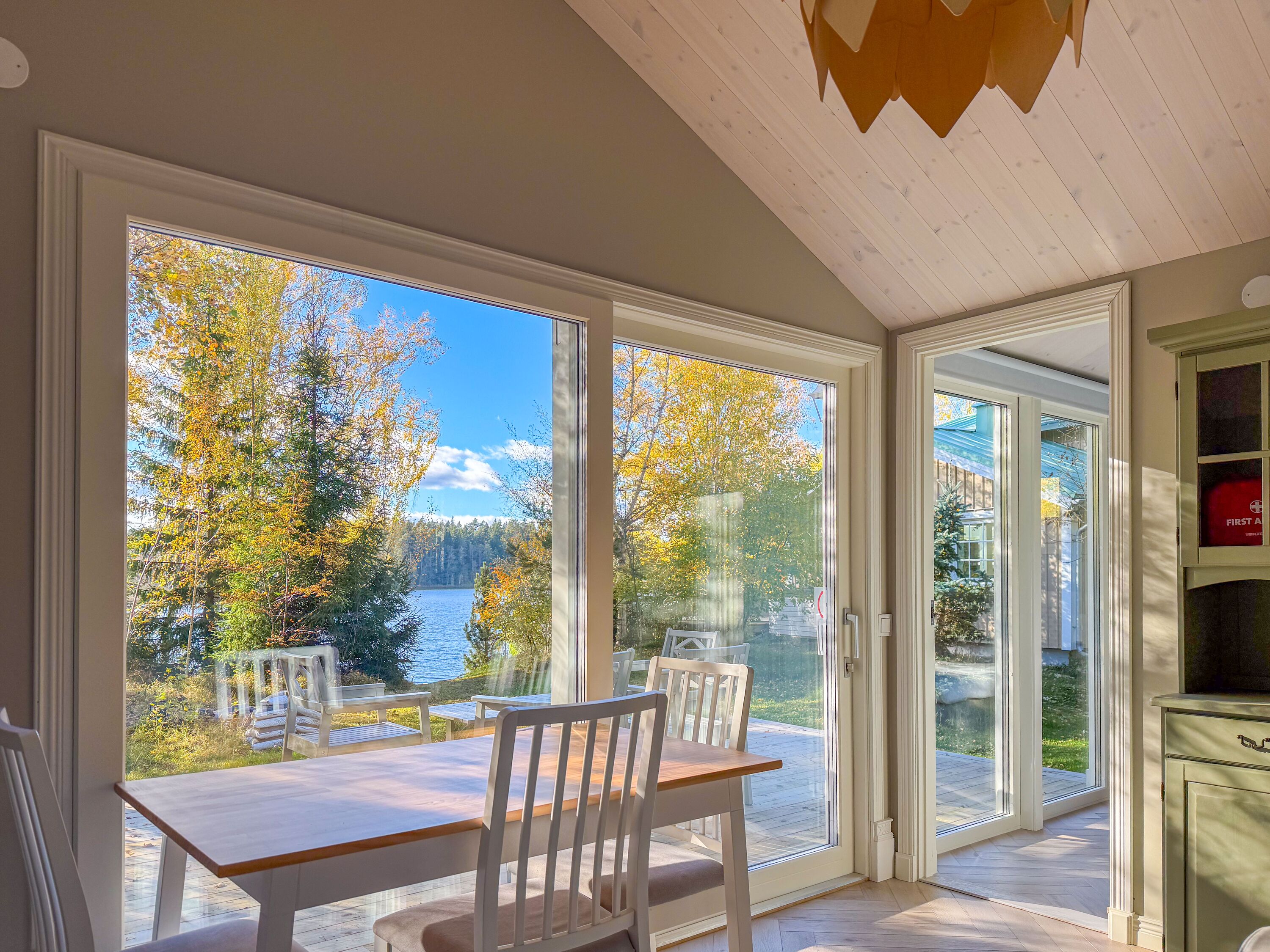 Blick vom Gästehaus durch die große Glastür auf den See - auch das Gästehaus hat seine eigene neue Terrasse