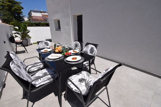 Teilüberdachte Terrasse mit: Markise, Esstisch   Stühlen, Holzkohlegrill