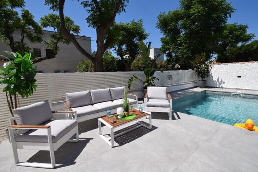 Teilüberdachte Terrasse mit: Markise, Esstisch   Stühlen, Holzkohlegrill, Loungebereich, Sonnenliegen.