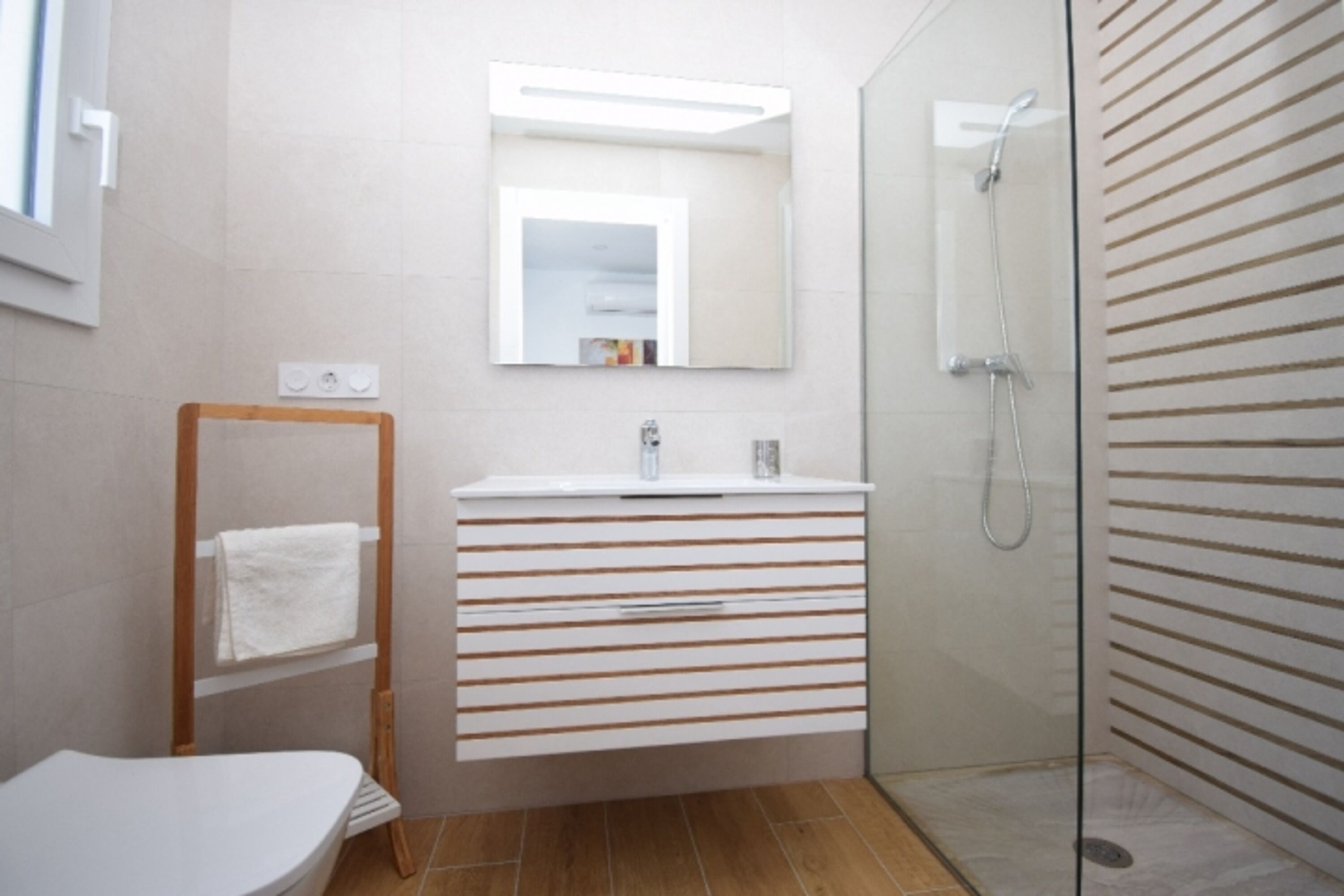 Bad en Suite mit ebenerdiger Dusche, Waschbecken und WC