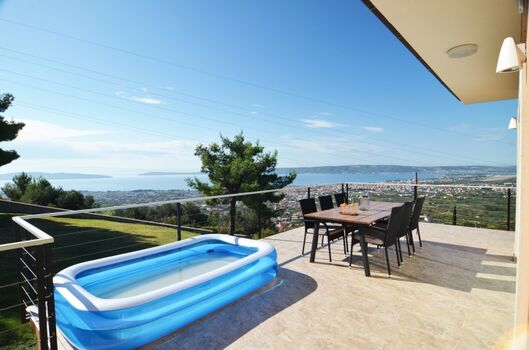 Große Sonnenterrasse mit Essbereich und Liegestühlen