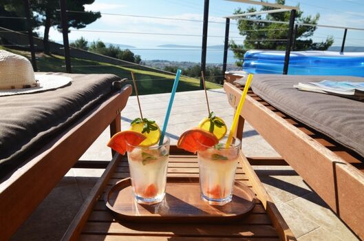 Große Sonnenterrasse mit Essbereich und Liegestühlen