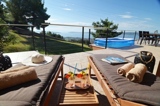 Große Sonnenterrasse mit Essbereich und Liegestühlen