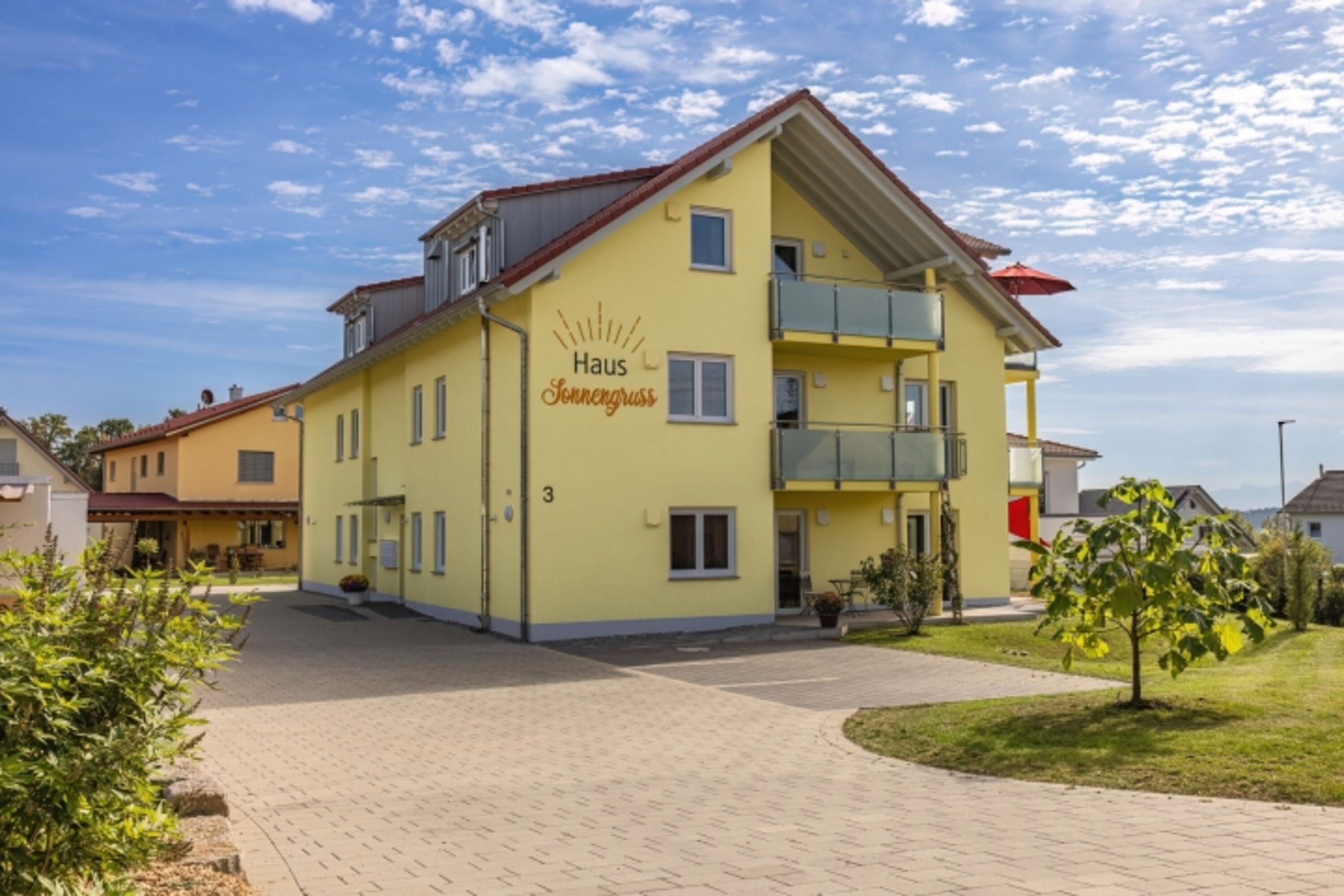 Hausansicht mit Parkplätzen