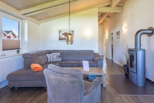 Ferienhaus Hallig Hooge – Großzügiger Wohnbereich mit bequemer Sofalandschaft und Kaminofen