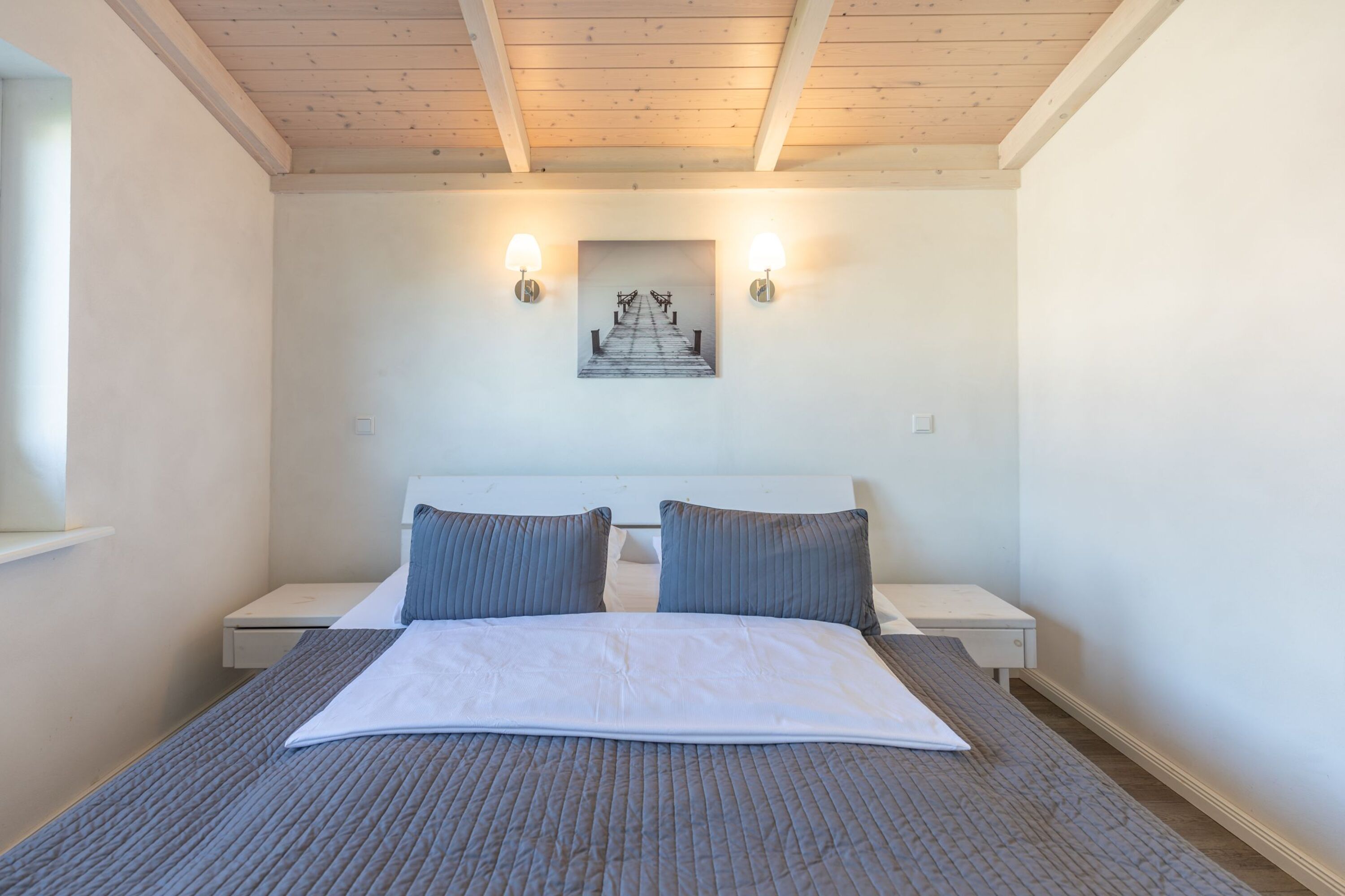 Ferienhaus Hallig Hooge – Gemütliches Schlafzimmer mit Doppelbett unter heller Holzdecke