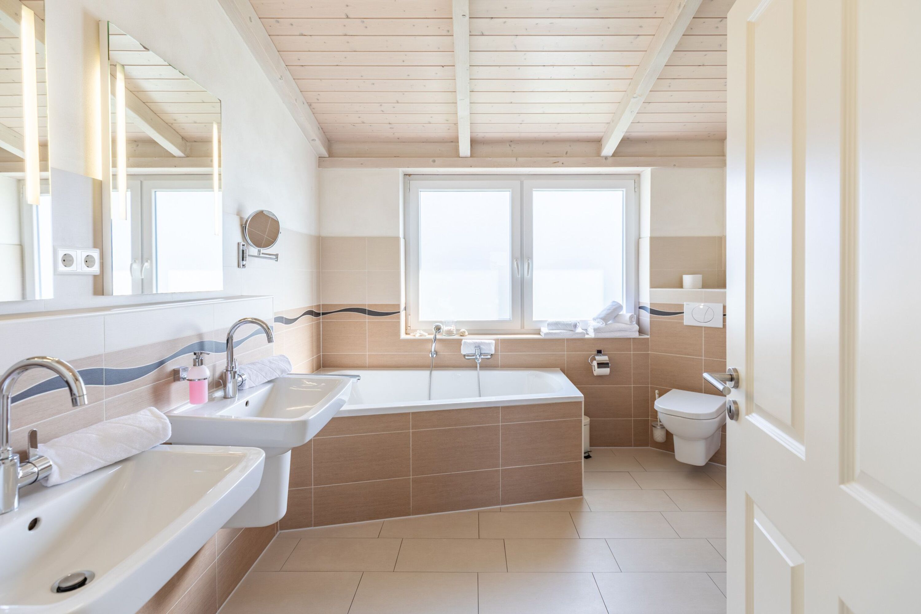 Ferienhaus Hallig Hooge – Großzügiges Badezimmer mit Badewanne und zwei Waschbecken
