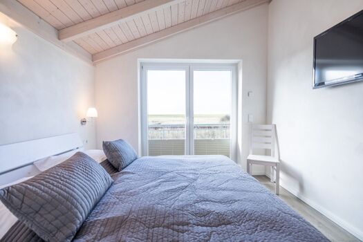 Ferienhaus Basstölpel -Schlafzimmer 2 im OG mit großem Doppelbett in 180x200 und TV