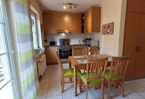 Küche mit Esstisch und Zugang zur Terrasse 