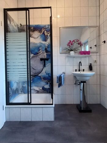 modernes Bad mit Dusche und Wand-WC im OG