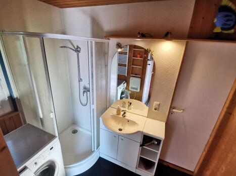 Badezimmer mit Dusche und Waschmaschine