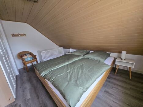 Schlafzimmer mit überlangen Doppelbett (je Matratze 90x210 cm) und Babybett