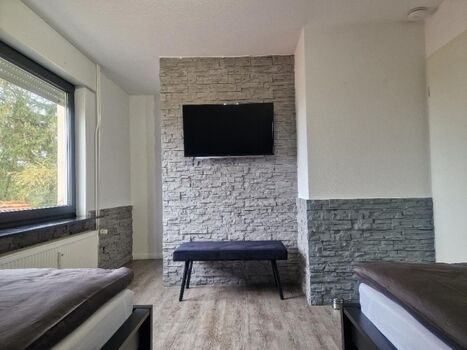 Schlafzimmer mit TV und begehbarem Kleiderschrank