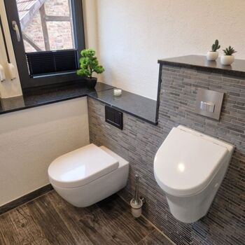 Badezimmer mit Toilette und Pissior